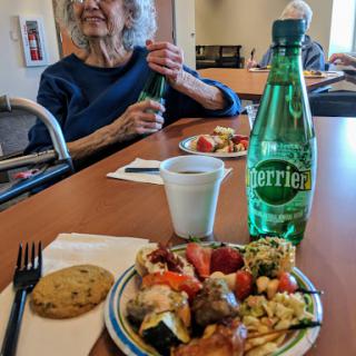 A delightful meal shared among friends, featuring colorful dishes and refreshing Perrier.
