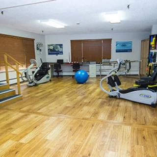 A well-equipped fitness room with exercise machines and a stability ball.