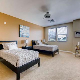 A modern bedroom with twin beds and neutral color scheme.
