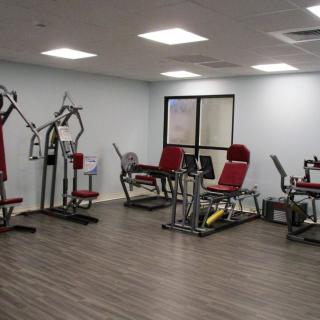 A modern gym room with various exercise machines and equipment.