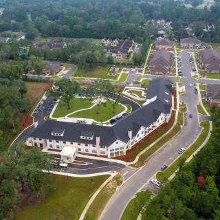 Aerial view of a modern building complex surrounded by roads and greenery.
