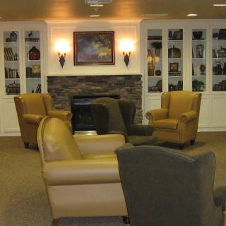 A cozy lounge area featuring comfortable chairs and a fireplace.