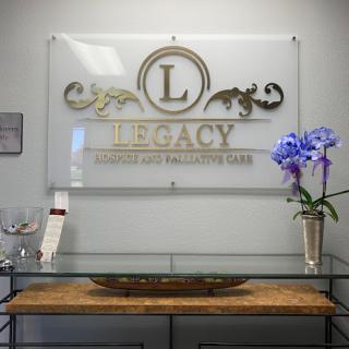 A sleek reception area featuring a decorative sign for 'Legacy' adorned with an elegant flower arrangement.