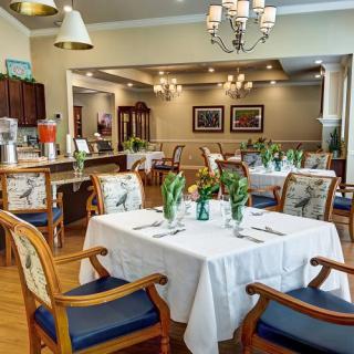 An elegant dining room with neatly set tables and comfortable chairs, featuring tasteful decor and ambient lighting.