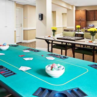 A well-equipped recreation room featuring a poker table with cards and chips ready for play.