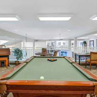 Spacious game room featuring a billiard table and comfortable seating.