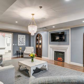 A stylish and modern living room with a chandelier, fireplace, and comfortable seating.