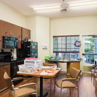 A communal kitchen and dining area with appliances and a table.