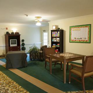 A cozy living room area with seating, a television, and a bookshelf.