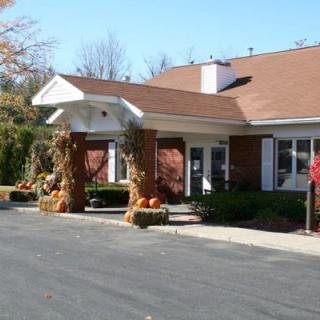 A building decorated with autumn-themed items, including pumpkins and corn stalks, at the entrance.