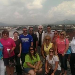 A group of people posing outdoors with a scenic background.