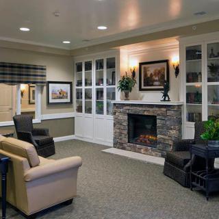 A cozy living room featuring a stone fireplace and comfortable seating with modern decor.