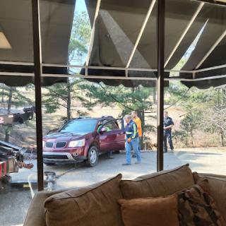 A cozy interior view looking out towards a red car and people interacting outside.
