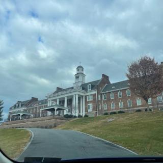 A view of a historic building framed by a cloudy sky.