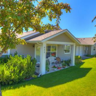 A cozy house with a well-maintained front yard on a sunny day.