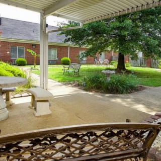 A peaceful patio with outdoor seating and lush greenery.