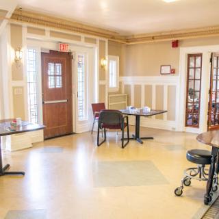 A well-lit lobby area featuring tables and chairs, designed for comfort and accessibility.