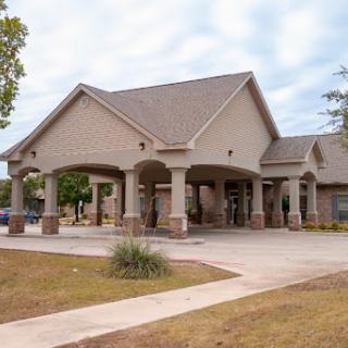 A modern residential building with a welcoming entrance and landscaped surroundings.