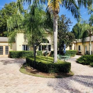 A luxurious house with a beautifully landscaped garden and palm trees.