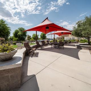 A beautiful outdoor seating area featuring a red canopy, perfect for gatherings on a sunny day.