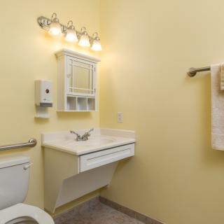 A clean and simple bathroom with a wall-mounted sink and cabinet.