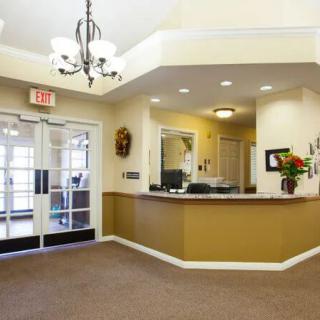 A welcoming reception area with a desk, decorative lighting, and entrance doors.