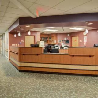 A modern hospital reception desk with office equipment and warm lighting.