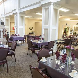 An elegant dining area with neatly arranged tables and floral decorations.