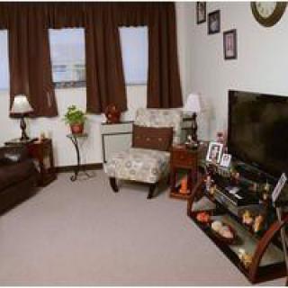 A cozy living room with a television, comfortable seating, and warm decor.