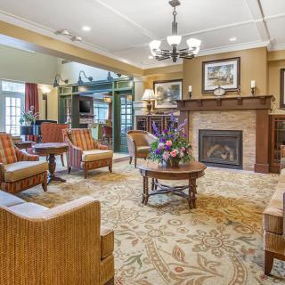 A cozy living room with elegant furniture arranged around a fireplace.