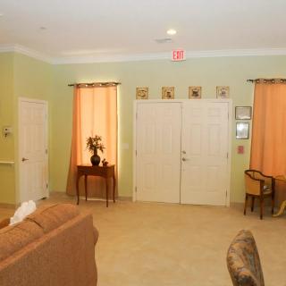 A cozy living room with soft lighting, featuring a sofa, decorative table, and curtains.