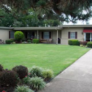 A suburban house with a well-maintained lawn and driveway.