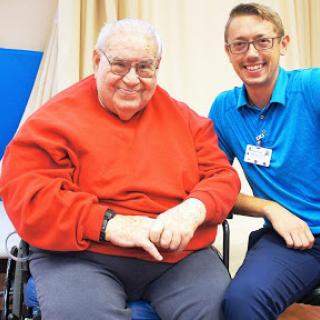 A joyful moment shared between an elderly man and his caregiver.
