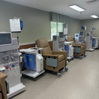 A view of a dialysis treatment area featuring multiple medical chairs and equipment in a healthcare facility.