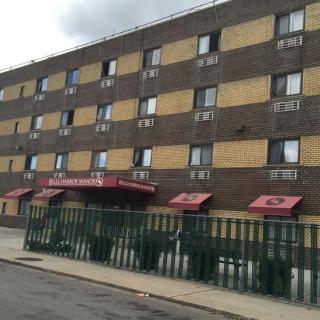 A residential apartment building with several floors and a fenced entrance.