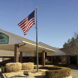 An American flag waves in front of a building entrance on a sunny day.