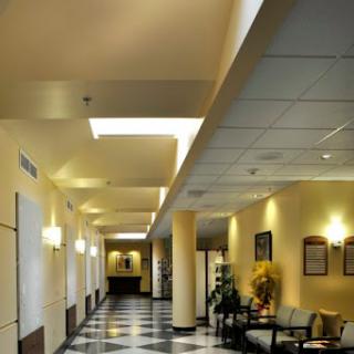 A well-lit lobby featuring modern design elements, including a checkered floor and comfortable seating.