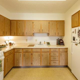 A kitchen with wooden cabinets and standard appliances.