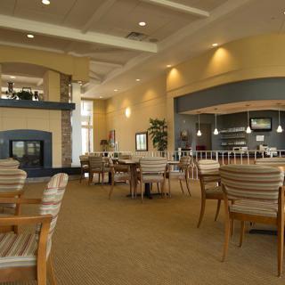 A cozy restaurant interior with tables and chairs arranged in a spacious dining area.