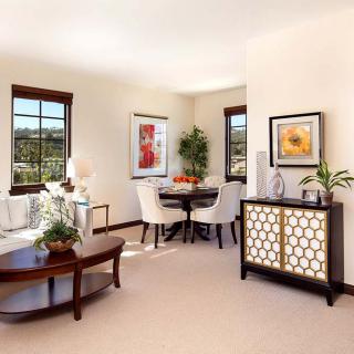 A modern living room with stylish furniture, decorated with plants and art, illuminated by natural light.
