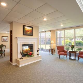 A cozy living room featuring a fireplace, large windows, and comfortable seating.