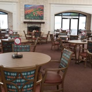 An empty restaurant dining area with tables and chairs neatly arranged.