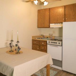 A compact kitchen with a dining table adorned with candles.