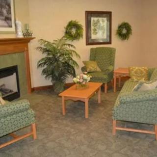 A cozy living room with green furniture and a fireplace.