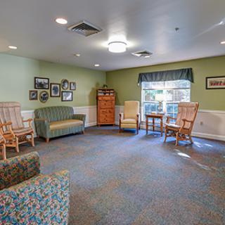 A cozy living room with sofas and chairs, featuring soft lighting and decor.