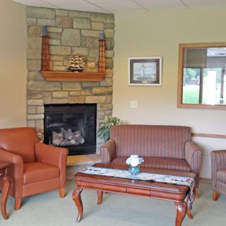 A cozy living room with a stone fireplace, comfortable seating, and elegant decor.