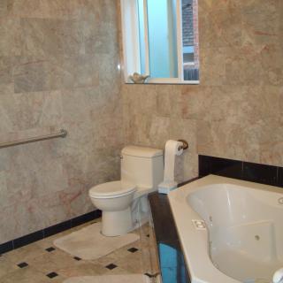 A modern bathroom with tiled walls and a bathtub.