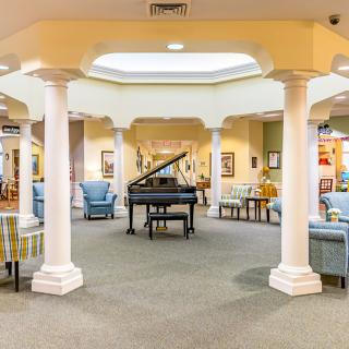 A beautifully designed lobby featuring a grand piano, elegant columns, and comfortable seating areas.