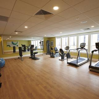 A spacious gym with exercise equipment including treadmills and stationary bikes.