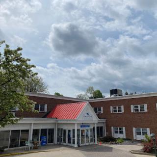 A building with a red roof under a cloudy sky.